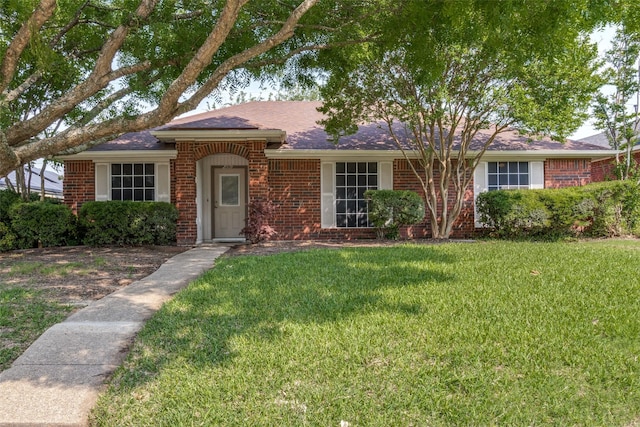 single story home with a front lawn and brick siding