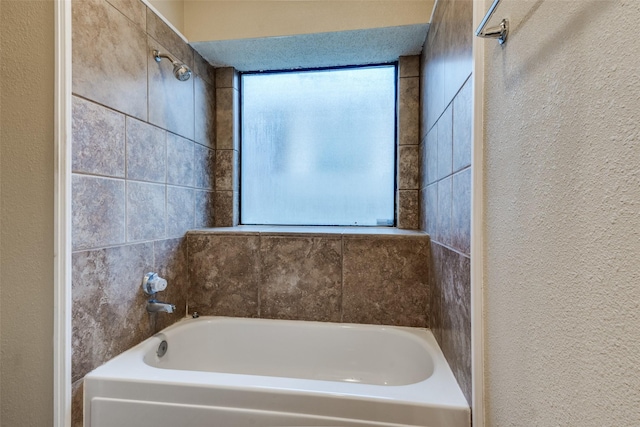 full bath with a textured wall and a garden tub