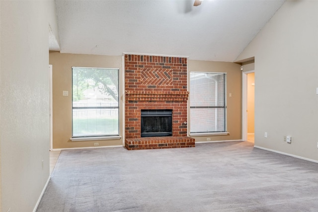unfurnished living room with carpet flooring, baseboards, a fireplace, and vaulted ceiling
