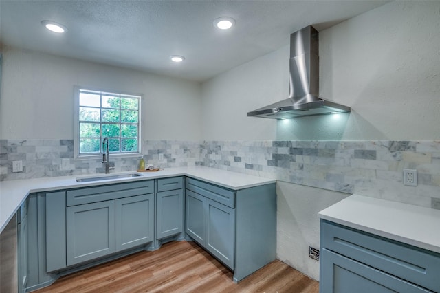 1104 Cortez St, Denison, TX 75020 - kitchen with a sink, wall chimney range hood, light wood finished floors, light countertops, and recessed lighting