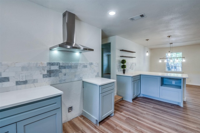1104 Cortez St, Denison, TX 75020 - kitchen with wall chimney exhaust hood, light wood-style flooring, a peninsula, light countertops, and recessed lighting