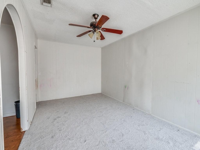 2203 Gould Ave, Fort Worth, TX 76164 - carpeted spare room with ceiling fan, arched walkways, and a textured ceiling