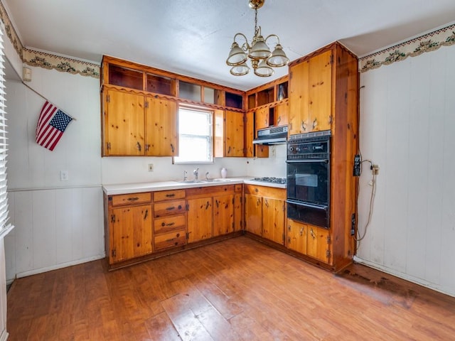 2203 Gould Ave, Fort Worth, TX 76164 - kitchen featuring black oven, a warming drawer, light wood-style floors, light countertops, and a chandelier