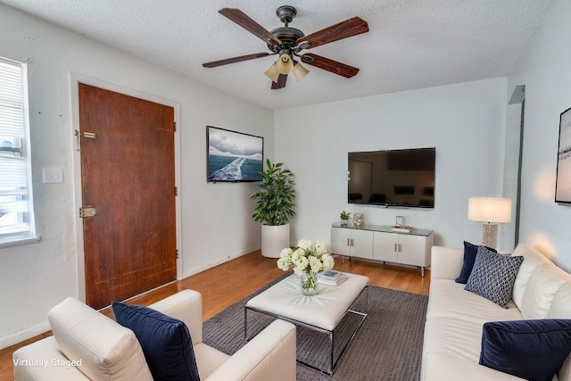 2203 Gould Ave, Fort Worth, TX 76164 - living room featuring a ceiling fan, wood finished floors, a textured ceiling, and baseboards
