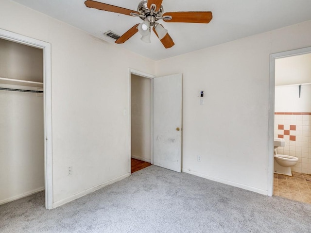 2203 Gould Ave, Fort Worth, TX 76164 - unfurnished bedroom with carpet, connected bathroom, tile walls, a closet, and ceiling fan