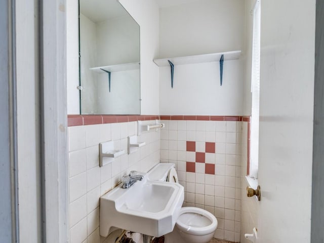 2203 Gould Ave, Fort Worth, TX 76164 - half bath featuring tile walls, a sink, toilet, and a wainscoted wall