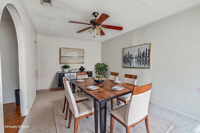 2203 Gould Ave, Fort Worth, TX 76164 - dining room featuring a ceiling fan, arched walkways, a textured ceiling, and baseboards