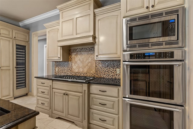 6021 Canyon Trl, Waco, TX 76657 - kitchen with stainless steel appliances, cream cabinetry, crown molding, and tasteful backsplash