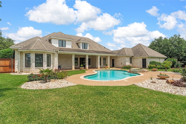6021 Canyon Trl, Waco, TX 76657 - back of property with stone siding, a pool with connected hot tub, and a tile roof