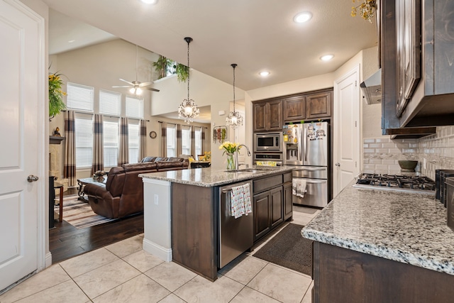 4302 Meadow Hawk Dr, Arlington, TX 76005 - kitchen featuring stainless steel appliances, dark brown cabinets, ceiling fan, open floor plan, and backsplash