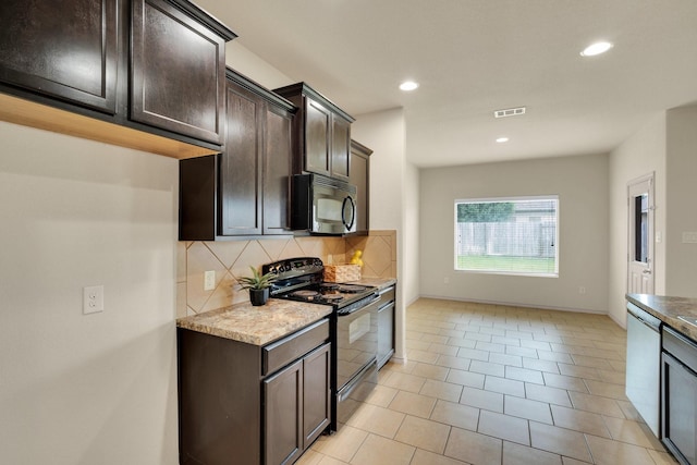 8213 White Hart Dr, Fort Worth, TX 76179 - kitchen with black electric range, stainless steel microwave, decorative backsplash, dark brown cabinets, and recessed lighting