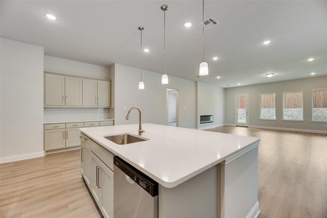 7113 El Matador Dr, Rowlett, TX 75088 - kitchen with dishwasher, a sink, light wood-type flooring, a kitchen island with sink, and light countertops