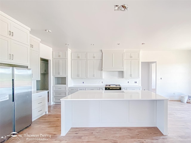 132 Pine Springs Cv, Tuscola, TX 79562 - kitchen with freestanding refrigerator, backsplash, white cabinetry, a spacious island, and light countertops