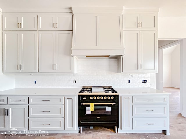 132 Pine Springs Cv, Tuscola, TX 79562 - kitchen with double oven range, exhaust hood, light countertops, tasteful backsplash, and white cabinetry