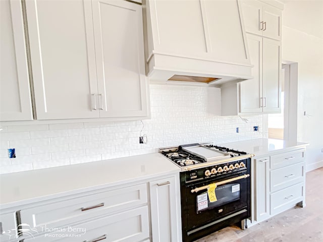 132 Pine Springs Cv, Tuscola, TX 79562 - kitchen featuring black gas range, premium range hood, light countertops, and white cabinets