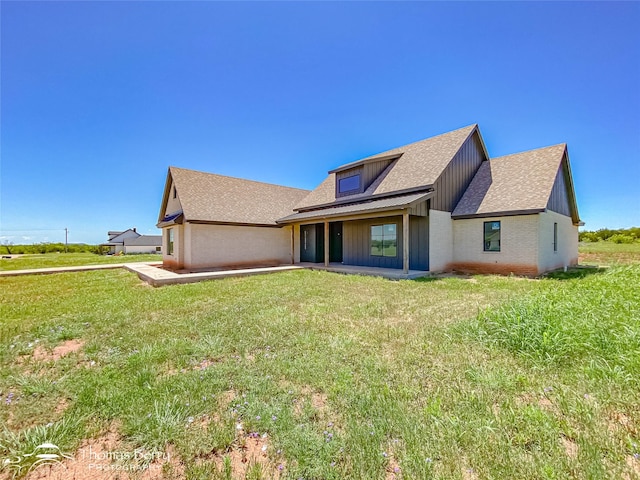 132 Pine Springs Cv, Tuscola, TX 79562 - rear view of house featuring a shingled roof, a lawn, board and batten siding, and brick siding
