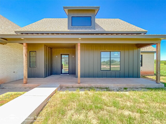 132 Pine Springs Cv, Tuscola, TX 79562 - entrance to property with roof with shingles, a patio area, board and batten siding, and brick siding