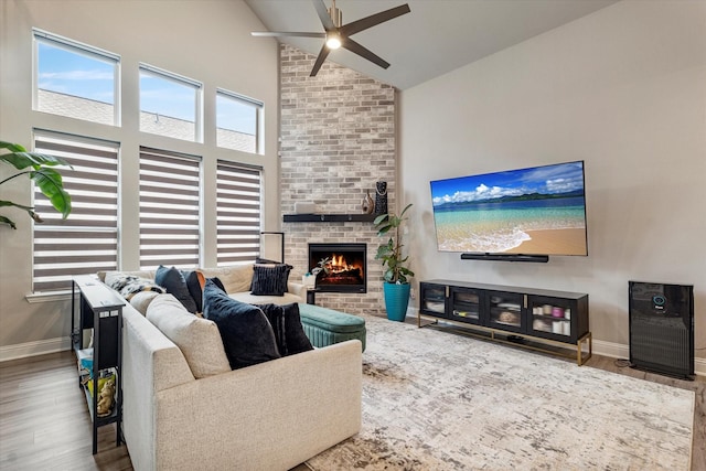 1806 Clouded Wren Dr, Arlington, TX 76005 - living room featuring ceiling fan, baseboards, wood finished floors, high vaulted ceiling, and a fireplace