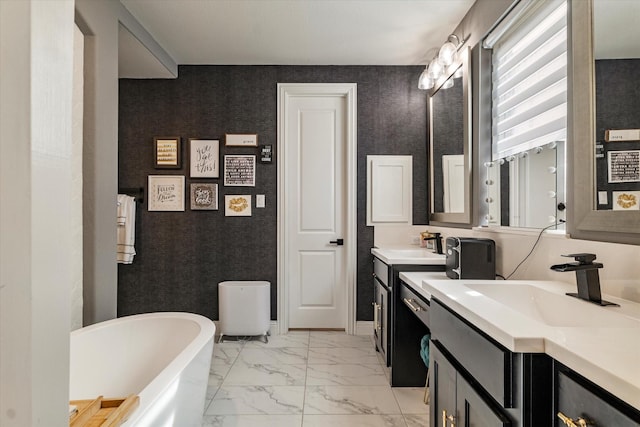 1806 Clouded Wren Dr, Arlington, TX 76005 - bathroom featuring marble look tile flooring, a freestanding bath, two vanities, and baseboards