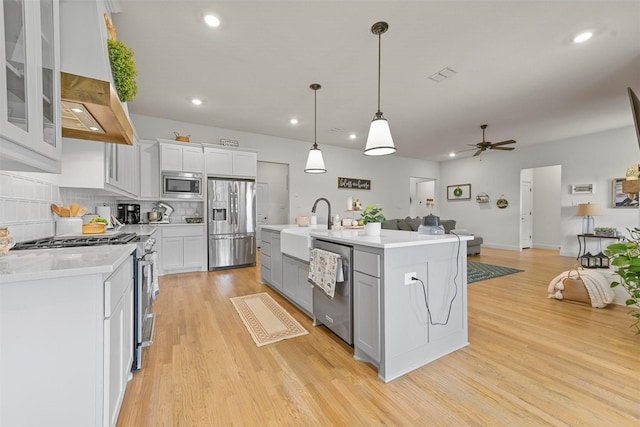1511 Horseshoe Ct, Justin, TX 76247 - kitchen with stainless steel appliances, open floor plan, exhaust hood, light countertops, and ceiling fan