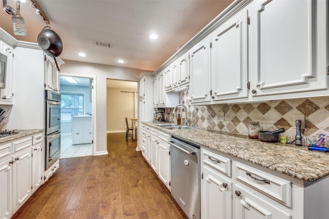 1507 Greenbrier Dr, Sherman, TX 75092 - kitchen featuring stainless steel appliances, a sink, tasteful backsplash, dark wood-style flooring, and white cabinets