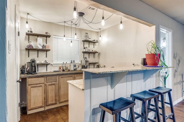 1507 Greenbrier Dr, Sherman, TX 75092 - kitchen with open shelves, dark wood finished floors, a breakfast bar area, light stone countertops, and brown cabinets