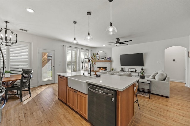 615 Louder Way, Fate, TX 75087 - kitchen featuring dishwasher, a sink, arched walkways, a warm lit fireplace, and light countertops
