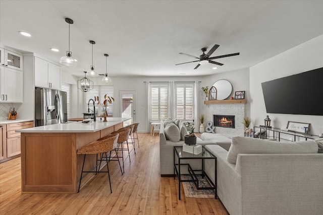 615 Louder Way, Fate, TX 75087 - living area featuring recessed lighting, a lit fireplace, ceiling fan, and light wood-style flooring