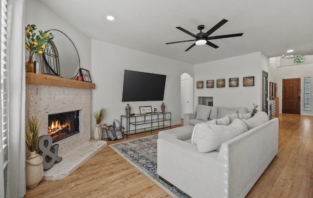 615 Louder Way, Fate, TX 75087 - living area with a brick fireplace, wood finished floors, ceiling fan, recessed lighting, and arched walkways