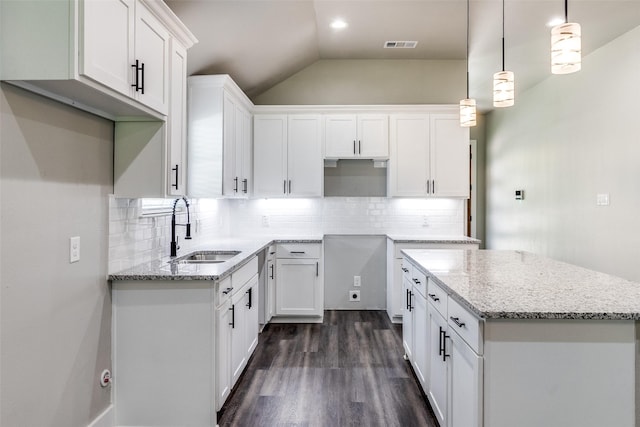 3235 Pine St, Dallas, TX 75215 - kitchen featuring a sink, light stone counters, white cabinets, dark wood finished floors, and lofted ceiling