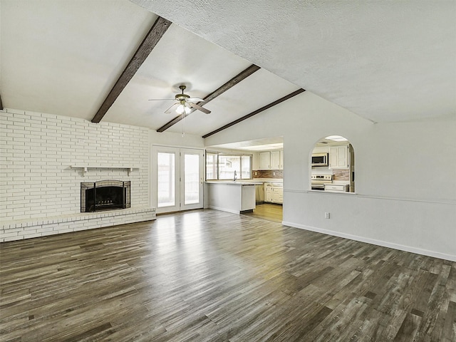 5632 Twitty St, The Colony, TX 75056 - unfurnished living room with ceiling fan, dark wood-type flooring, a fireplace, a sink, and baseboards