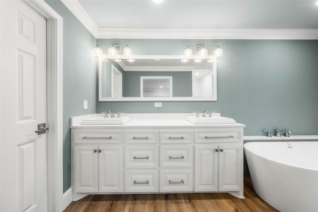 9916 Sandalwood Dr, Woodway, TX 76712 - full bath featuring ornamental molding, double vanity, a freestanding tub, and wood finished floors