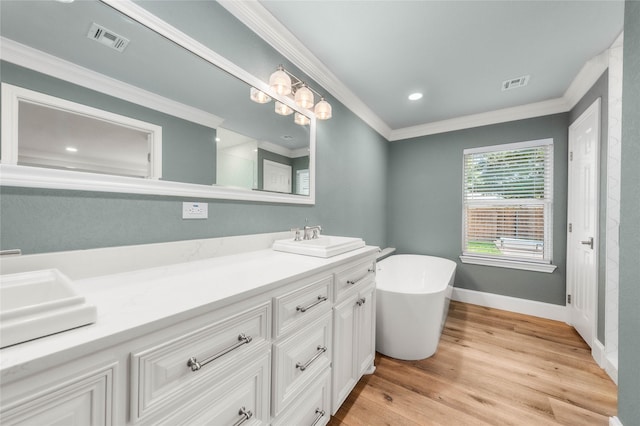 9916 Sandalwood Dr, Woodway, TX 76712 - bathroom featuring double vanity, ornamental molding, a freestanding bath, wood finished floors, and baseboards