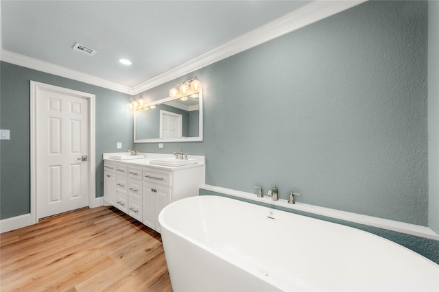 9916 Sandalwood Dr, Woodway, TX 76712 - full bathroom featuring crown molding, double vanity, wood finished floors, a freestanding bath, and baseboards