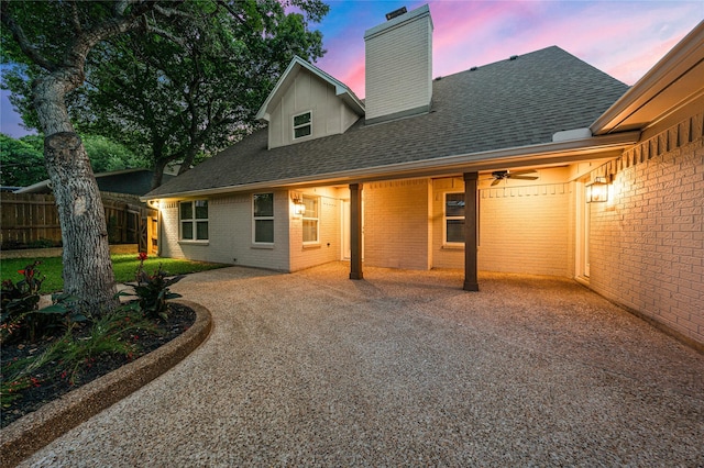 9916 Sandalwood Dr, Woodway, TX 76712 - rear view of property featuring gravel driveway, a chimney, ceiling fan, brick siding, and roof with shingles