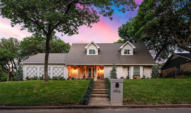 9916 Sandalwood Dr, Woodway, TX 76712 - cape cod home featuring a front lawn, brick siding, a shingled roof, and an attached garage