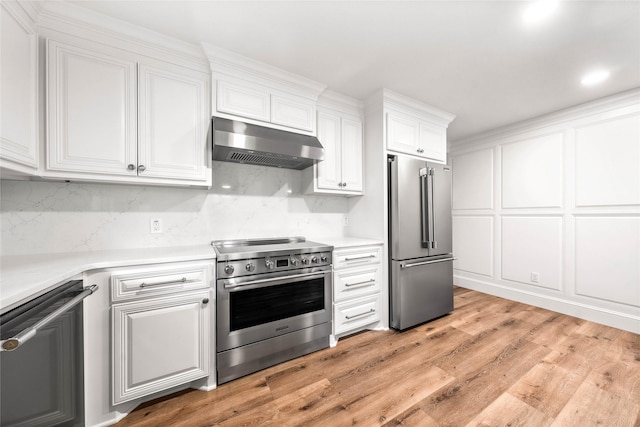 9916 Sandalwood Dr, Woodway, TX 76712 - kitchen with appliances with stainless steel finishes, under cabinet range hood, white cabinetry, light countertops, and recessed lighting