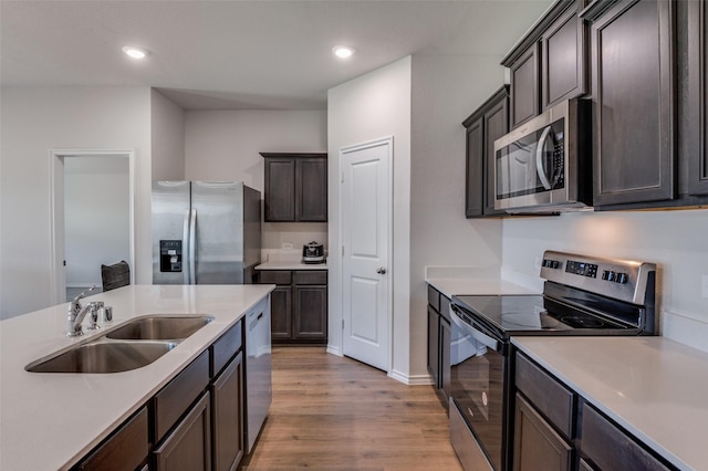 6534 Diver St, Princeton, TX 75407 - kitchen featuring appliances with stainless steel finishes, a sink, light wood-style flooring, light countertops, and dark brown cabinets