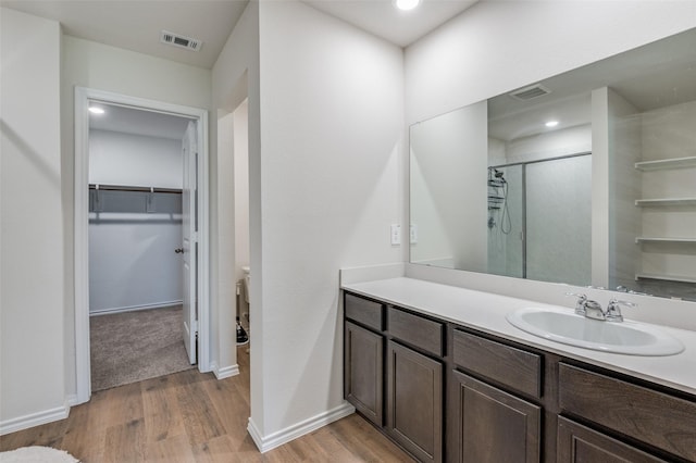6534 Diver St, Princeton, TX 75407 - full bathroom with wood finished floors, a stall shower, vanity, a spacious closet, and baseboards