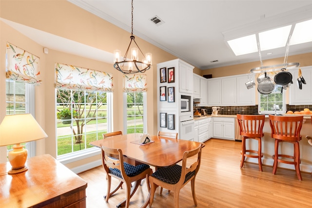 404 High Meadow Ln, Heath, TX 75032 - dining room with crown molding, a chandelier, and light wood finished floors