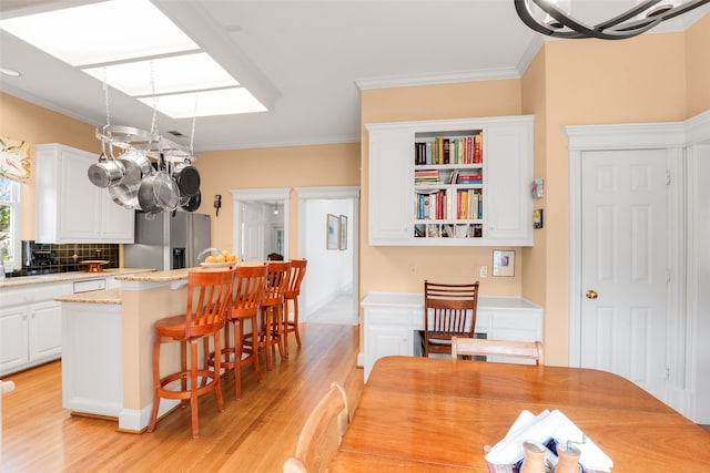 404 High Meadow Ln, Heath, TX 75032 - dining space with light wood-style flooring, ornamental molding, and a chandelier