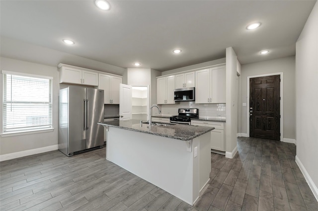 4142 Perch Dr, Forney, TX 75126 - kitchen with appliances with stainless steel finishes, a sink, wood finished floors, baseboards, and a center island with sink