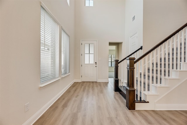 7107 Manhattan Dr, Rowlett, TX 75088 - entrance foyer featuring wood finished floors, healthy amount of natural light, stairway, baseboards, and a towering ceiling