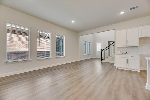 7107 Manhattan Dr, Rowlett, TX 75088 - unfurnished living room with stairs, light wood-style flooring, baseboards, and recessed lighting