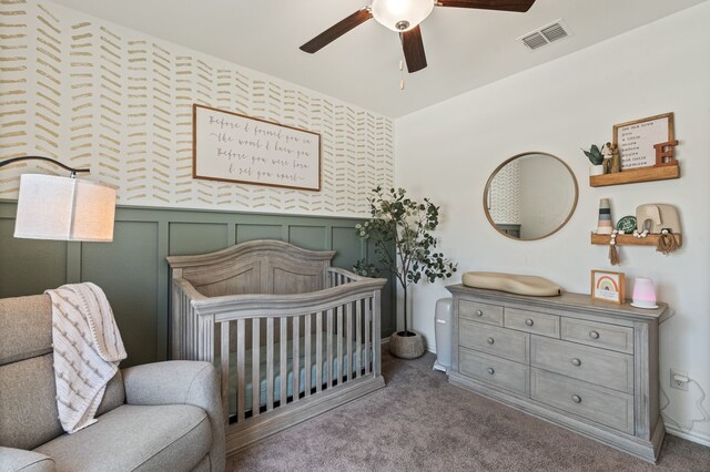 1701 Lake Grove Dr, Little Elm, TX 75068 - carpeted bedroom featuring a nursery area, ceiling fan, wainscoting, and baseboards