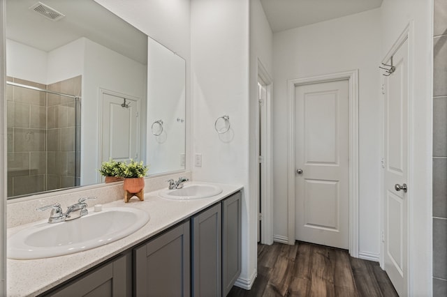 1701 Lake Grove Dr, Little Elm, TX 75068 - bathroom featuring wood finished floors, double vanity, and a tile shower