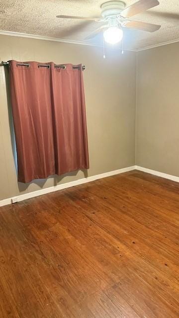 spare room featuring wood finished floors, ceiling fan, a textured ceiling, ornamental molding, and baseboards