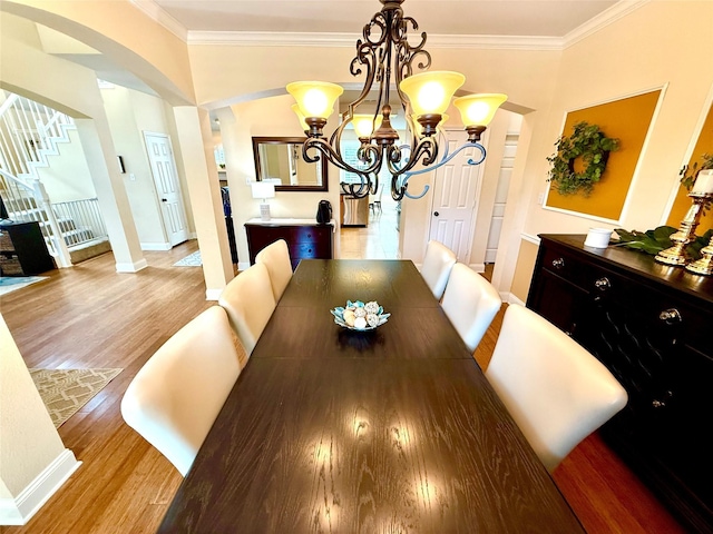 708 W Lonesome Dove Trl, Arlington, TX 76001 - dining room with arched walkways, crown molding, light wood-style floors, baseboards, and stairs