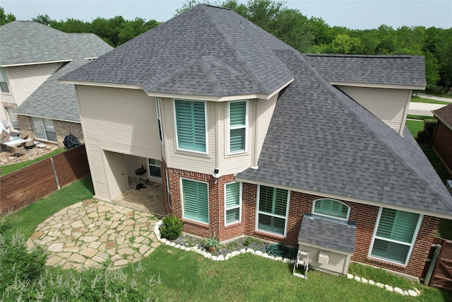 708 W Lonesome Dove Trl, Arlington, TX 76001 - back of property with roof with shingles, a patio, and brick siding