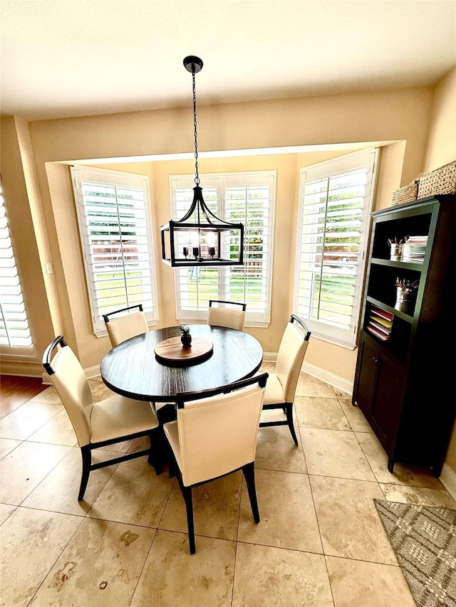 708 W Lonesome Dove Trl, Arlington, TX 76001 - dining area with light tile patterned flooring, baseboards, and a chandelier